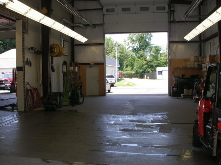 Drive-through maintenance bay inside a steel building with vehicles