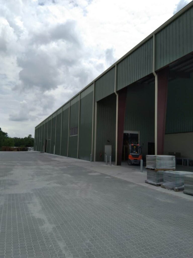 Exterior of a commercial steel industrial building with a forklift